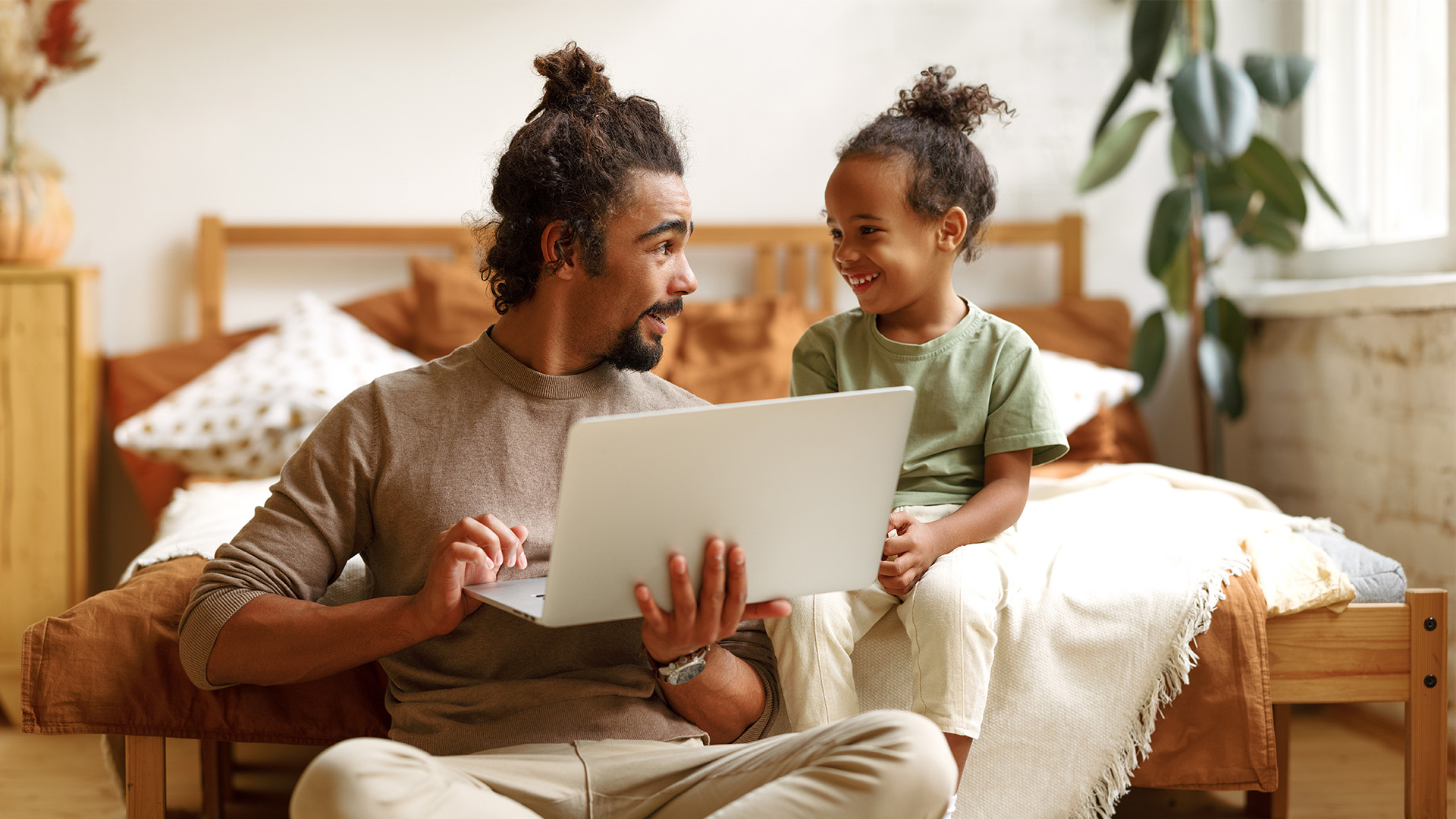Father using laptop while talking to child